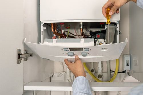 HVAC technician repairing an indoor boiler in Fort Collins
