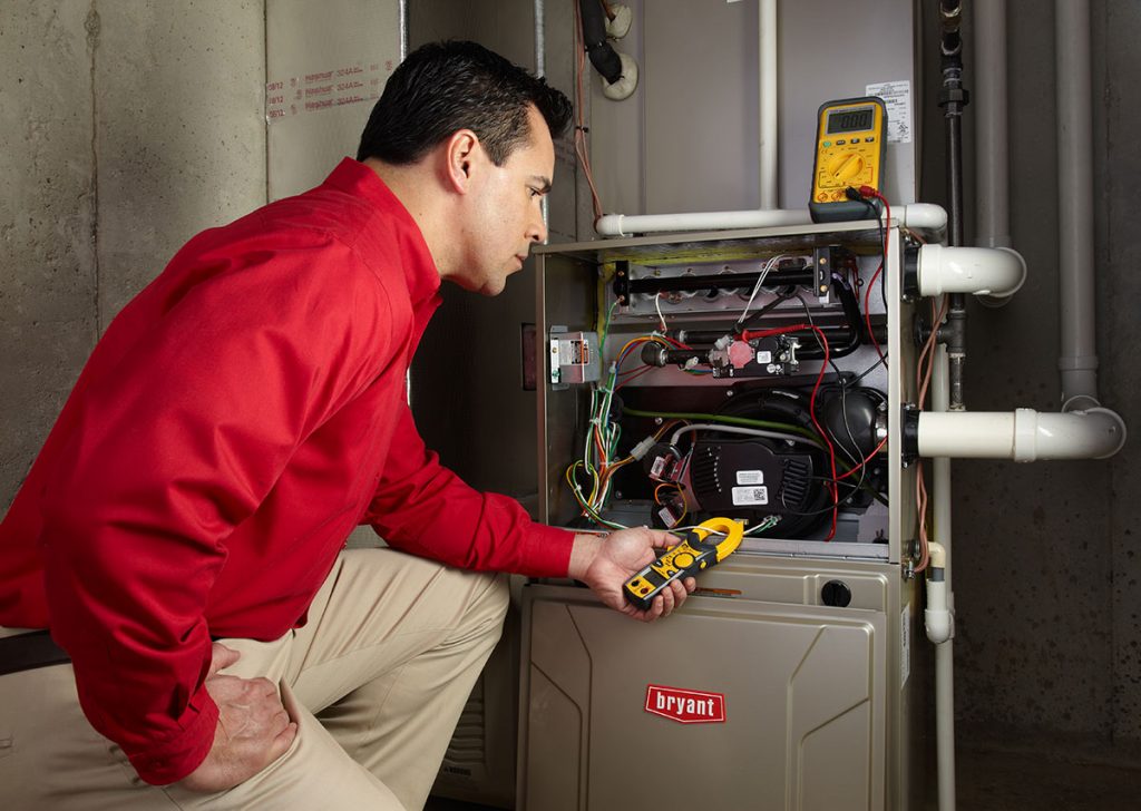HVAC technician repairing an indoor furnace in Fort Collins