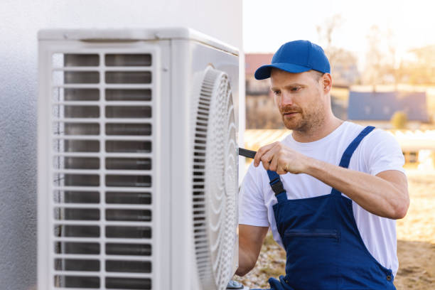HVAC technician servicing an outdoor air conditioning unit in Fort Collins