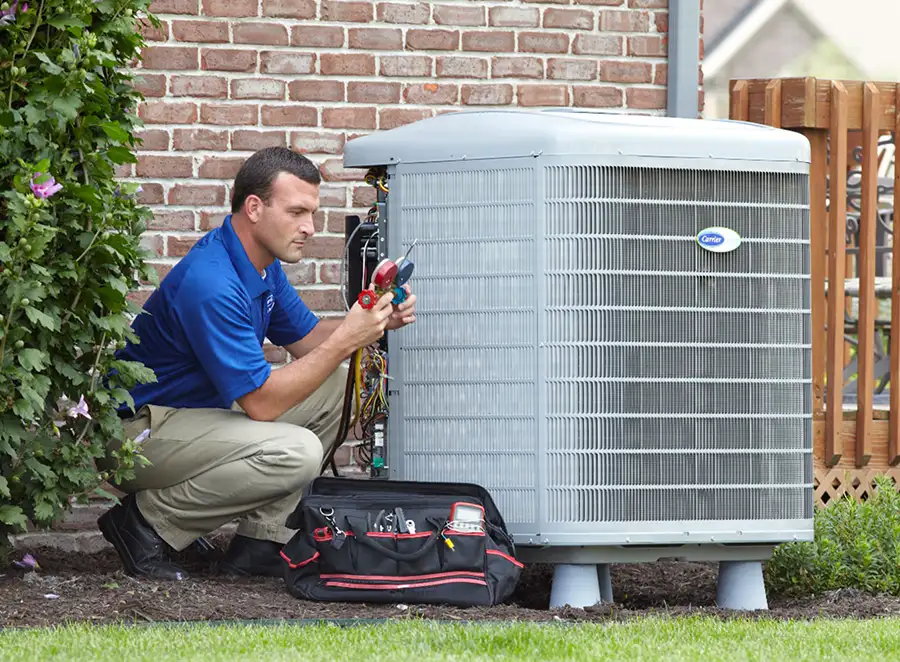 HVAC technician inspecting an outdoor air conditioning unit in Fort Collins