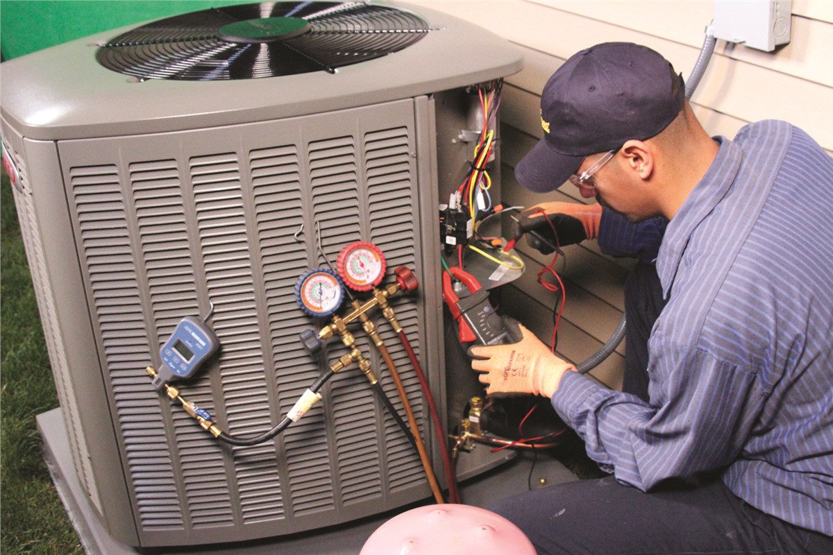 HVAC technician testing an outdoor air conditioning unit in Fort Collins