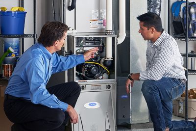 HVAC technician explaining furnace repair and maintenance to a homeowner in Fort Collins, CO