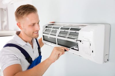 HVAC technician cleaning and repairing a ductless mini split AC in Fort Collins, CO