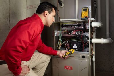 Heating and air conditioning technician servicing an indoor furnace in Fort Collins, CO